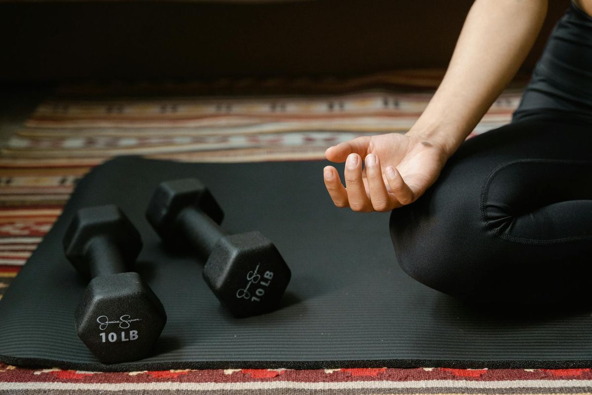 Close up of yoga equipment and a person in a meditation pose